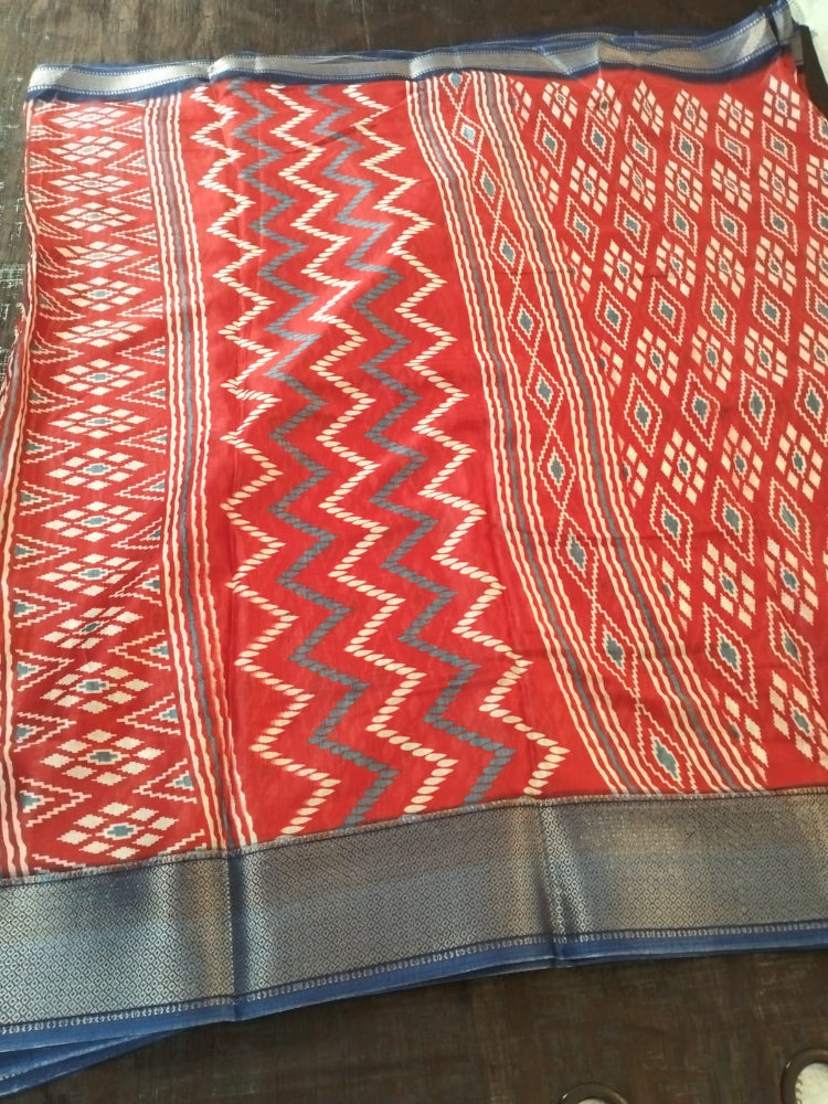 Red geometric design semi silk saree with rich blue border