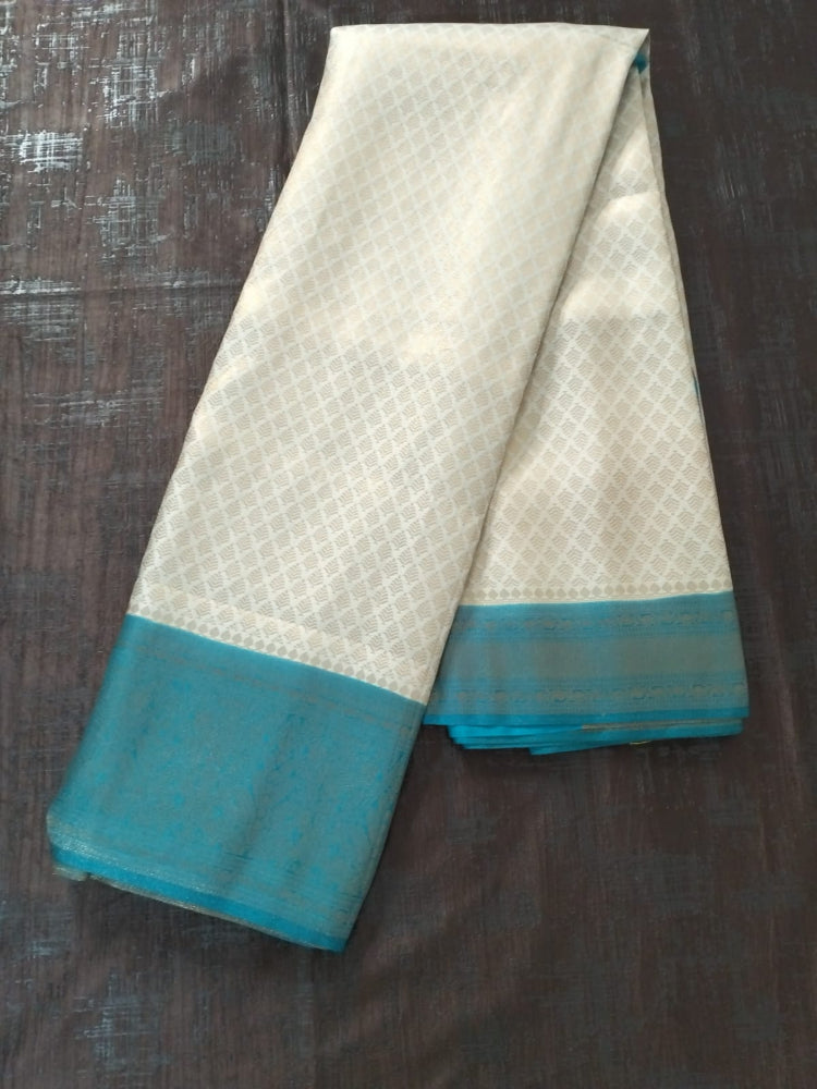 Pearl white with sea green border semi silk saree with golden self design